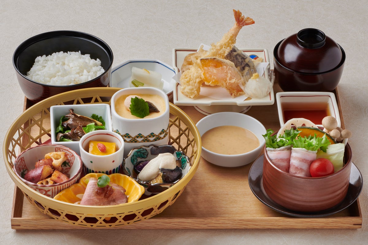 チーズと葉野菜を豊穣豚(ほうじょうとん)のバラ肉で巻いたせいろ蒸しとサクサクの天ぷらを主菜に、幅広くご支持いただいている副菜6種の籠盛りを組み合わせた、秋ならではの食材をあれもこれも少しずつ楽しめるイチオシのメニューです。 副菜6種には、店内で仕込んだ京鴨ロース柚子蜜煮をはじめ、味・歯ごたえ・香りが他の舞茸とは一線を画す黒舞茸と春菊のサラダ、ホクホクした食感がたまらない蓮根とさつまいものしょうゆ麴炒め、濃厚なかぼちゃ豆腐、じゅわっと旨味ひろがる秋茄子の白和えクリームかけ、ホッと温まる茶碗蒸しをご用意いたしました。